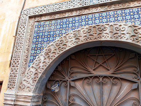 Old moroccan traditioal ornamented entrance of a house. Moroccan decorative building entrance.