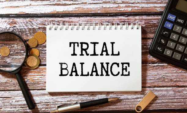 istock TRIAL BALANCE text on paper with magnifier, coffee and keyboard on grey background 1762348448