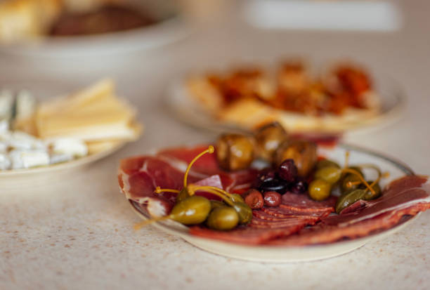 istock Close-up of plates with various delicious snacks on a white marble table. 1762348819
