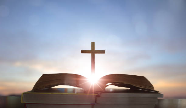 istock cross on open Bible with sunrise background 1762356092