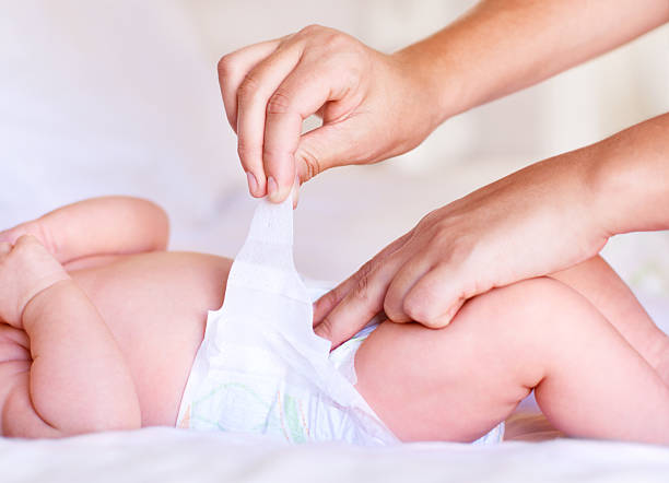 upewnij się, że jest prawidłowo przymocowana - changing diaper zdjęcia i obrazy z banku zdjęć