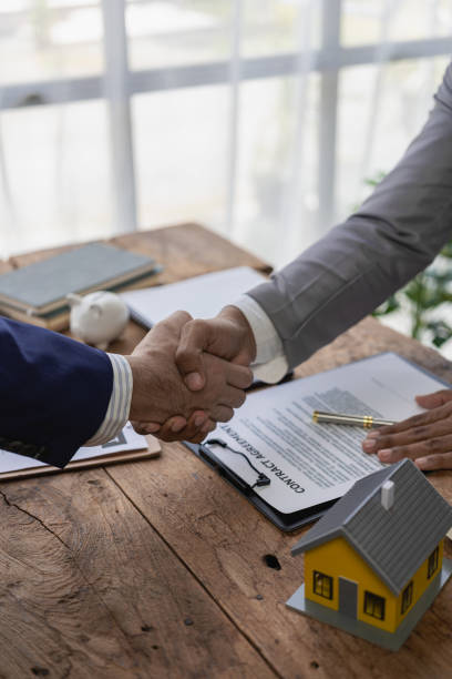 istock Real estate agent shakes hands with client after the contract is finalized after home insurance and investment loans. Agent and client shake hands after signing the contract to buy a home. 1762373474