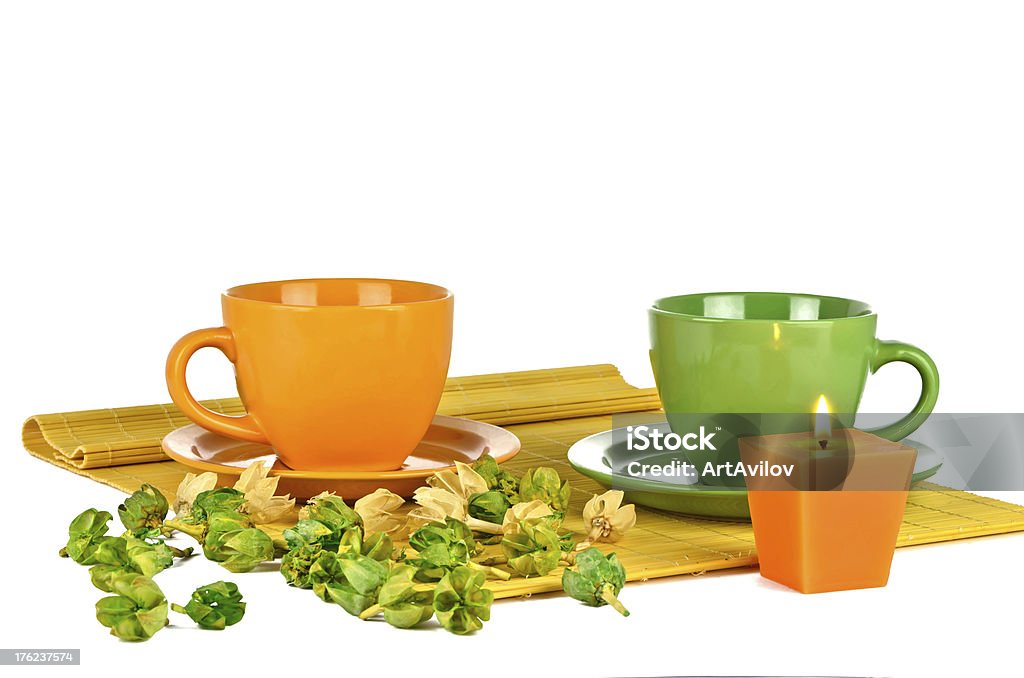 Two colorful cups with aromatic compound Two colorful cups with aromatic compound and a burning candle on a bamboo napkin Bamboo - Material Stock Photo