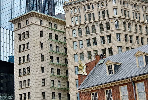Contrasting styles of architecture in downtown Boston with the red brick Old State House from the American Revolution against more modern structures.