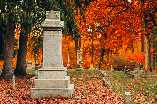 Beautiful fall cemetery with tall old and new grave stones