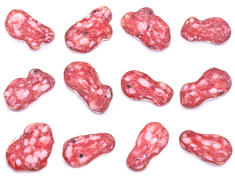 slices of Spanish Fuet thin dried salami sausage isolated on a white background.