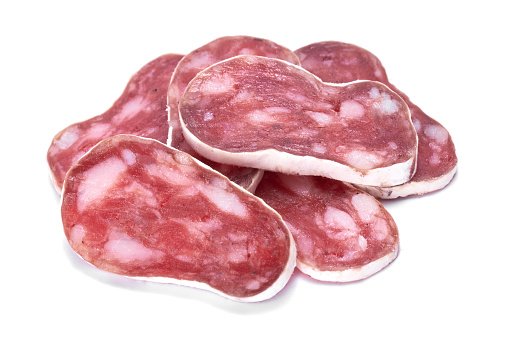 slices of Spanish Fuet thin dried salami sausage isolated on a white background.