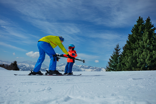 Father and little son skiing at the mountain