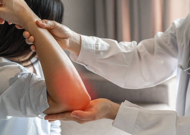 整形外科または理学療法士クリニックで理学療法の相談を受けている女性患者のリウマチ、肘の痛み、痛み、けいれん、しびれ、関節リウマチ、変形性関節症 - pain elbow physical therapy inflammation ストックフォトと画像