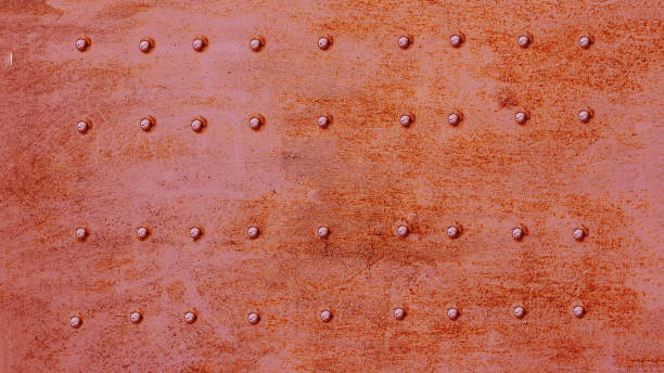 riveted metal surface, painted red. - metal rusty rust textured imagens e fotografias de stock