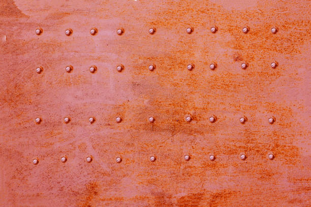 riveted metal surface, painted red. - metal rusty rust textured imagens e fotografias de stock