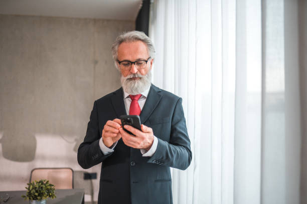 istock Bearded Businessman Using Smartphone At Home 1762410998