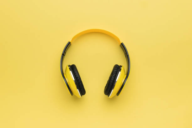 istock Yellow wireless headphones on a yellow background. 1762692925
