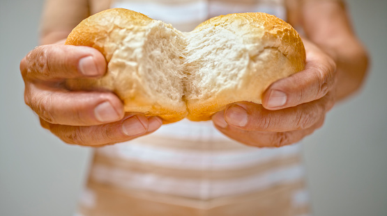 Close-up of man's hands breaking bread.