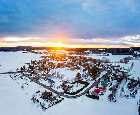 An aerial view of St-Donat, Quebec, Canada, showing the town covered in snow at sunset.