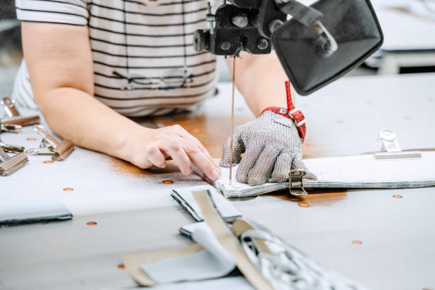 istock Female Worker Using Rubber Cutting Machine With Metal Glove In Sewing Factory 1762744249