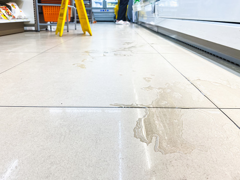 Water spill on the tiled floor in the mini mart.