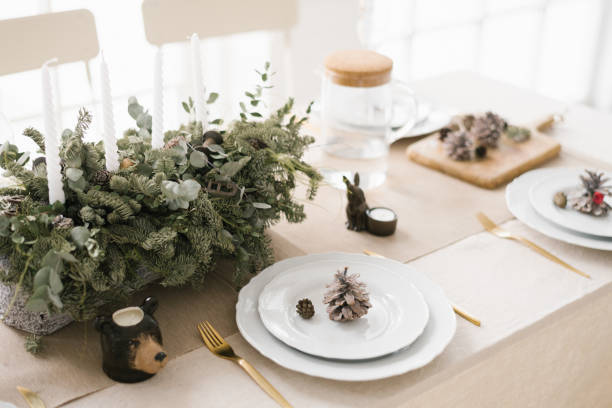 istock Stylish Christmas table setting: a composition of fir branches, white plates decorated with cones 1762848097