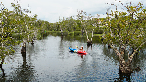 Women kayaking at Rayong Botanical Gardens, a wetland ecosystem open to the public to promote ecotourism, Klaeng district, Rayong, Thailand. Concept water sports adventure activities.