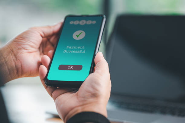 istock Businessman hand holds a smartphone on screen with message payment successful Concept. business, banking, financial online transactions with mobile devices. money sent transfer, shopping online, cyber 1762859835