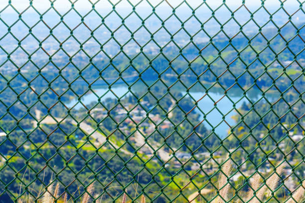 Diamond-mesh fence and defocused view of the picturesque Hollywood Reservoir in Los Angeles.