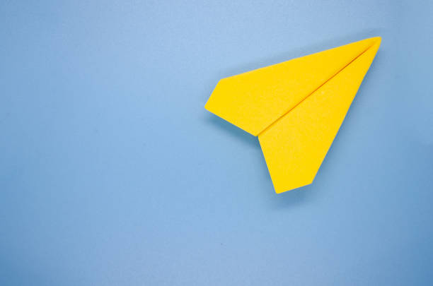 istock Top view of yellow paper airplane on blue background with customizable space for text. Copy space and plane concept. 1762912771