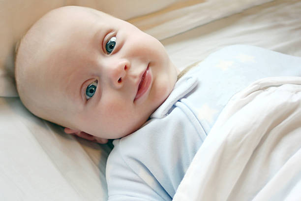 bebé en la cama - 5 month old fotografías e imágenes de stock