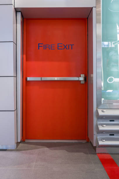 istock Emergency fire exit door. Closed up latch and rusty door handle of emergency exit. Push bar and rail for panic exit. Open one way door. steel of handle for the white door fire exit 1762934472