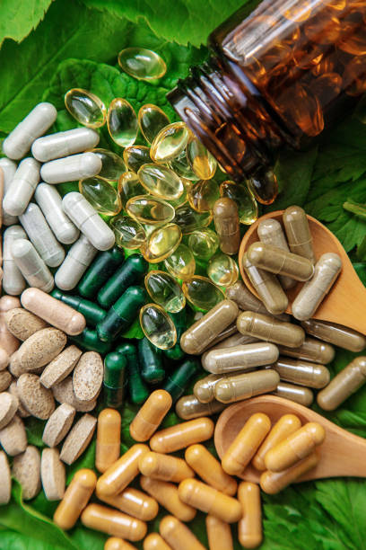 istock Capsules herb supplements on green leaves background. Selective focus. 1762968748