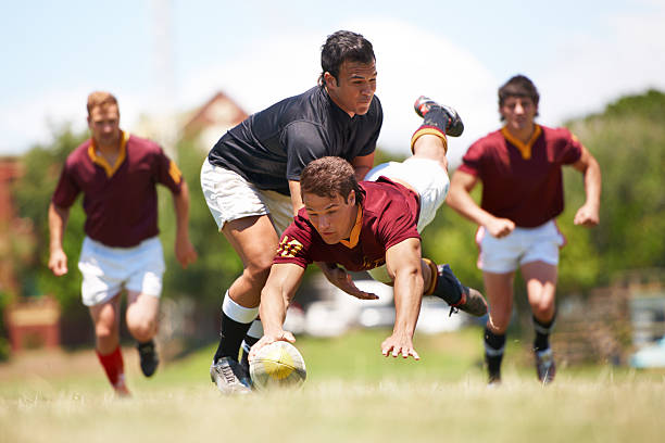 This game is not for the faint hearted A rugby game mid action with the one team member scoring a try rugby players stock pictures, royalty-free photos & images