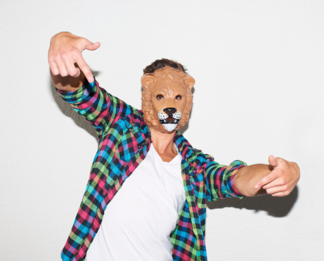 Young hipster guy wearing a lion mask and gesturing