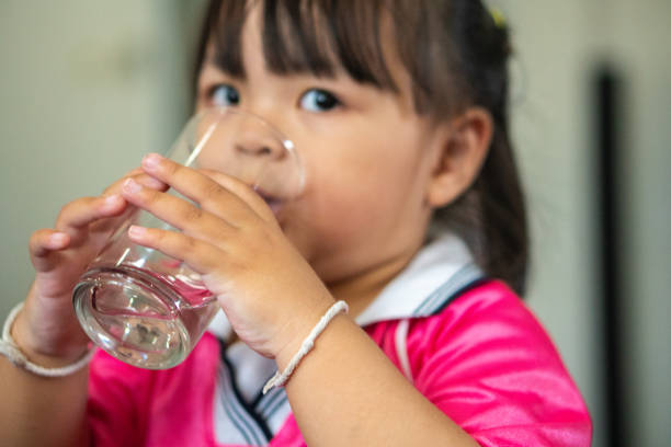 istock Asian kid drinking water at home. 1763022877