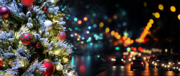 Christmas tree decorated with traditional Christmas decorations, illuminated by Christmas lights that flash with a play of shadows and lights wishing you a Merry Christmas. The snow-covered pine branches with Christmas balls. In the background the lights