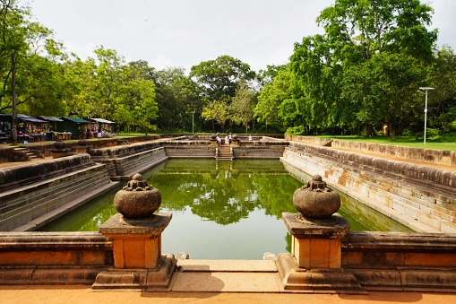 Jethawana Dagoba, Anuradhapura, Sri Lanka - May 07, 2022: Bathed in sunlight, the placid waters of the lake within Jethawana Dagoba glisten, enhancing the serenity of the ancient temple grounds and offering a moment of reflection for all who visit.