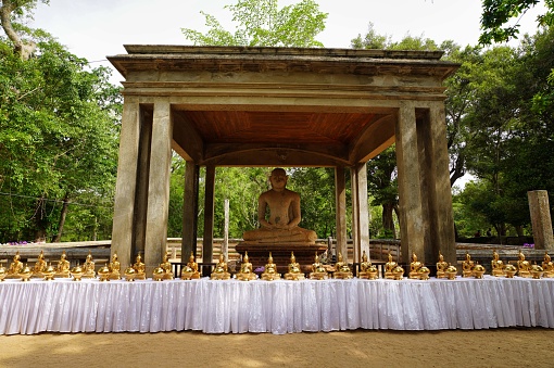 Jethawana Dagoba, Anuradhapura, Sri Lanka - May 07, 2022: A magnificent collection of gilded Buddha statues, capturing the essence of devotion and artistry, stand tall, reflecting the golden rays of the sun, and providing a mesmerizing visual feast for visitors and devotees alike.