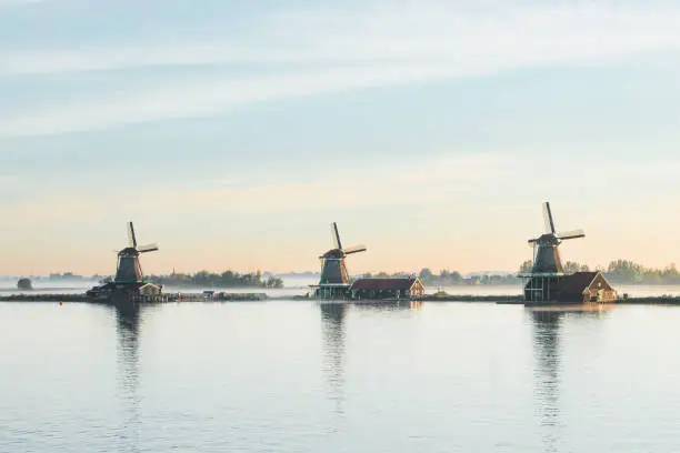 Photo of Popular tourist spot Zaanse Schans is near Amsterdam in the west of the Netherlands. Historical, realistic windmills during sunrise. Holland's landmark