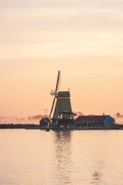 Photo of Popular tourist spot Zaanse Schans is near Amsterdam in the west of the Netherlands. Historical, realistic windmills during sunrise. Holland's landmark