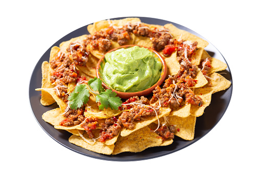 Plate of mexican nachos chips with cheese, meat and guacamole isolated on white background