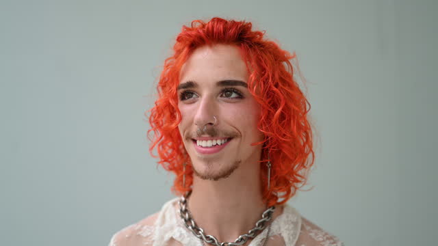 Facial close-up of cheerful gay man with colorful hair