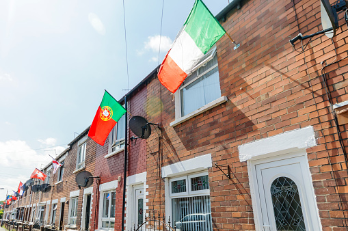 BELFAST, NORTHERN IRELAND. 04 JUN 2016: Houses in Iris Drive in West Belfast are decorated with the flags of all 24 countries that have qualified for the Euros 2016.  The residents organised a sweepstake, with each house having to fly the flag of their country.  It is believed to be the first time that the England and Northern Ireland flags have been flown voluntarily in this staunchly republican area of West Belfast.