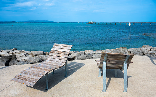 Two wooden empty deckchairs for sunbathing on the pier of Lake Constance - Bodensee - in swiss Altnau