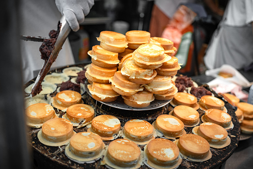 A street vendor is making wheel cakes