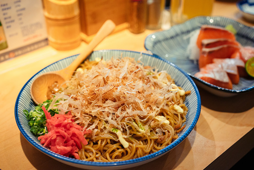 A serving of yakisoba in an izakaya, followed by a plate of sashimi