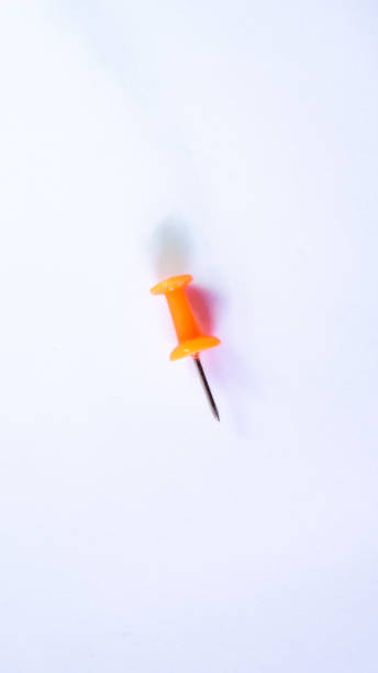 istock Push pin, orange and red, white background, macro photography 1763154609