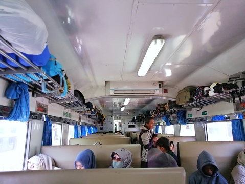 Jakarta Indonesia July 26 2023, Indonesia train know as KAI, economy class interior, passage with seats full of passengers traveling across cities.