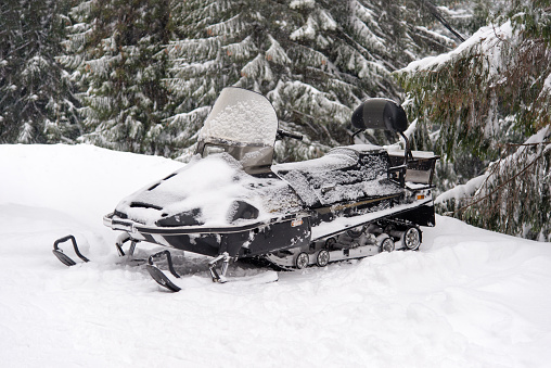 Snowmobile in a snowy landscape. Sports snowmobile in the mountains. Winter transport