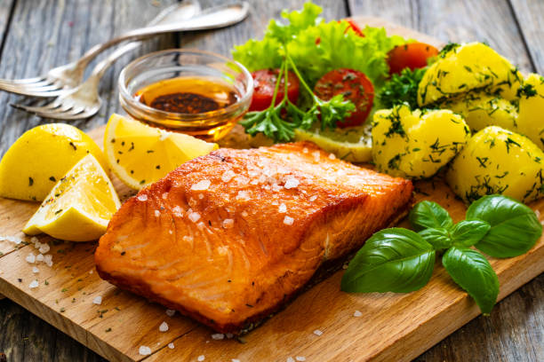 istock Seared salmon with boiled potatoes and fresh vegetables on wooden table 1763224909