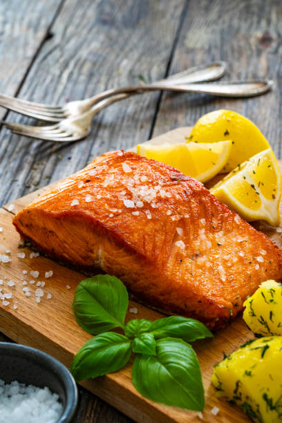 istock Seared salmon with boiled potatoes and fresh vegetables on wooden table 1763224930