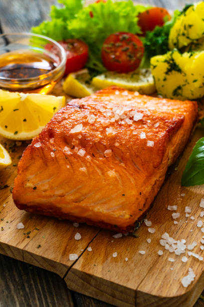 istock Seared salmon with boiled potatoes and fresh vegetables on wooden table 1763225995