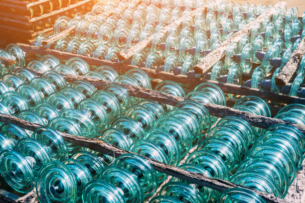 Glass transparent high-voltage insulator is in storage. Industrial background.